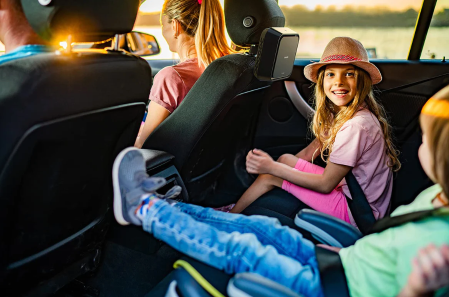 Happy family inside a car with a Philips car air purifier installed for clean air during travel