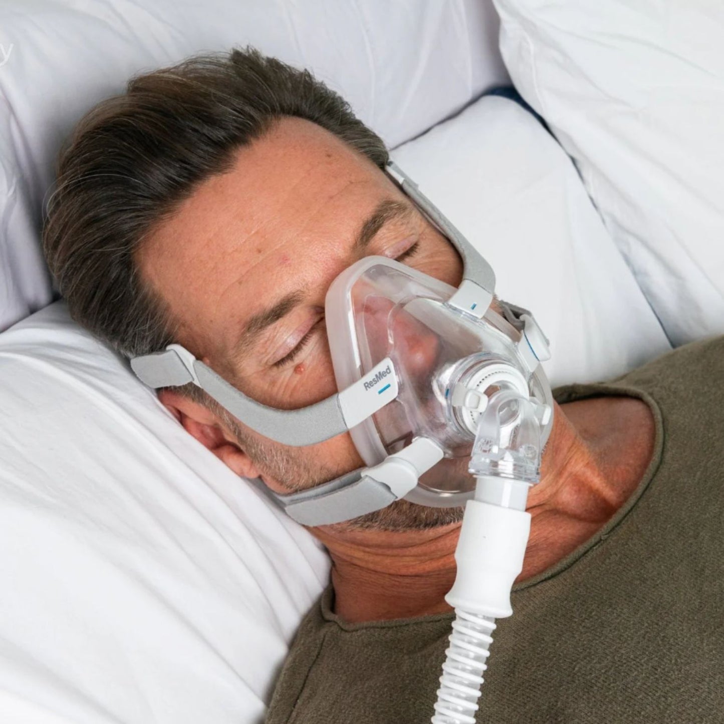 Man lying on bed wearing a resmed f20 mask with adjustable straps for comfortable CPAP therapy