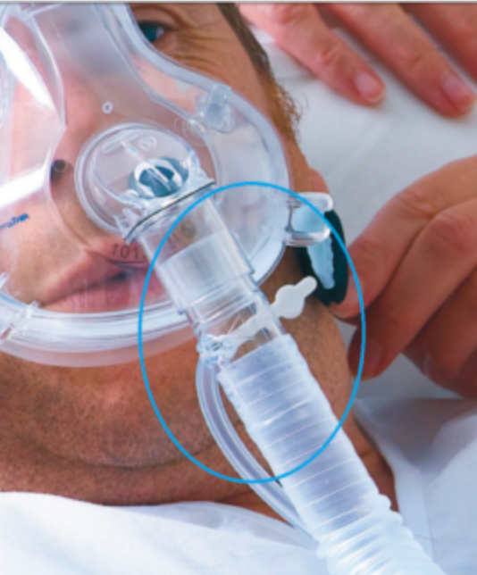 Philips Respironics Disposable Exhalation Port connector attached to a clear respiratory mask on a patient
