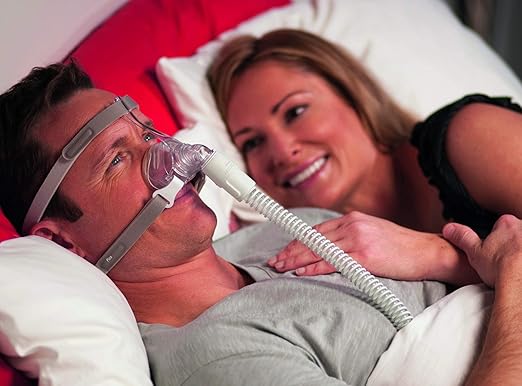 Man wearing pico nasal mask in bed with smiling woman beside him for comfortable breathing
