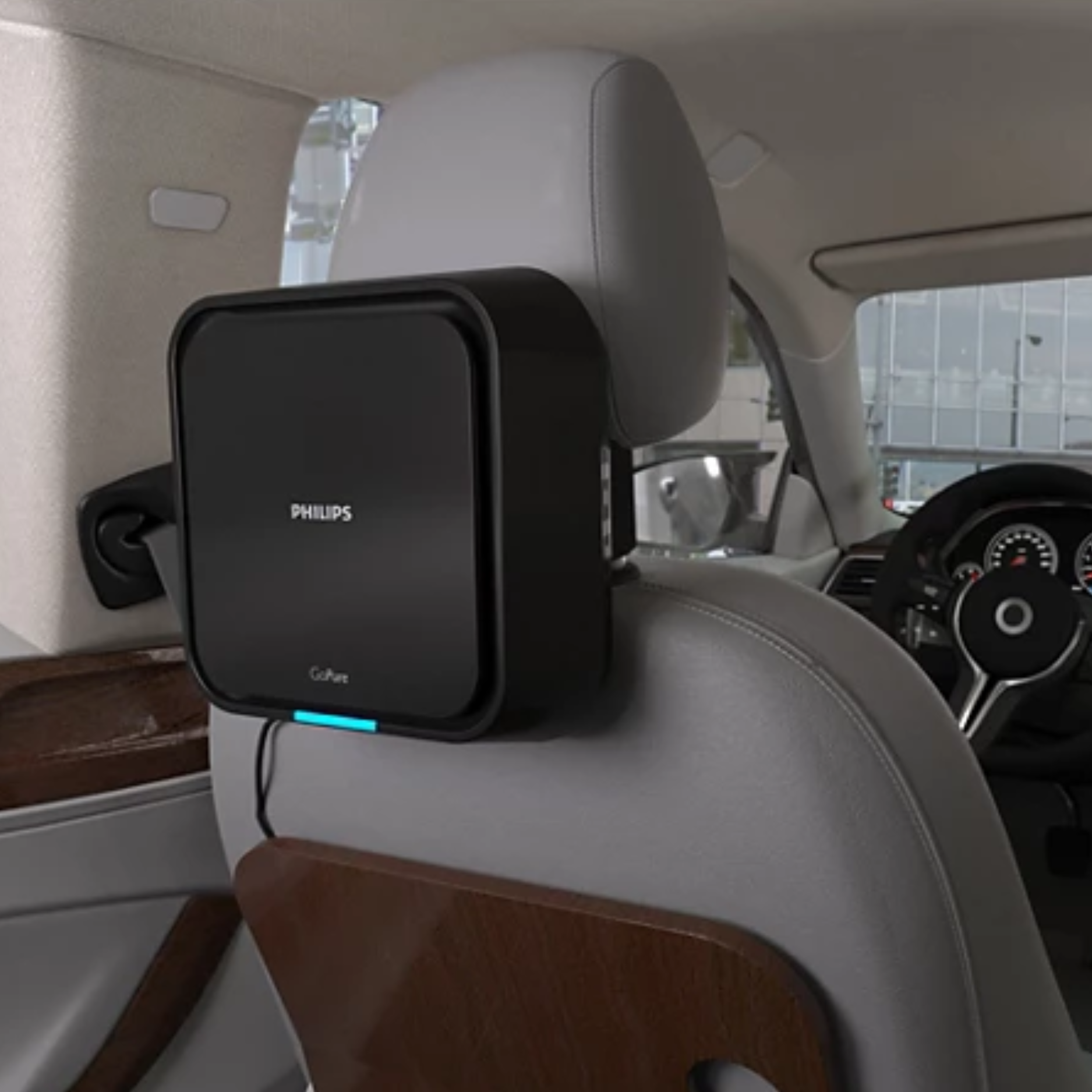 Philips Car Air Purifier 5211 mounted on the back of a gray car seat headrest inside a vehicle