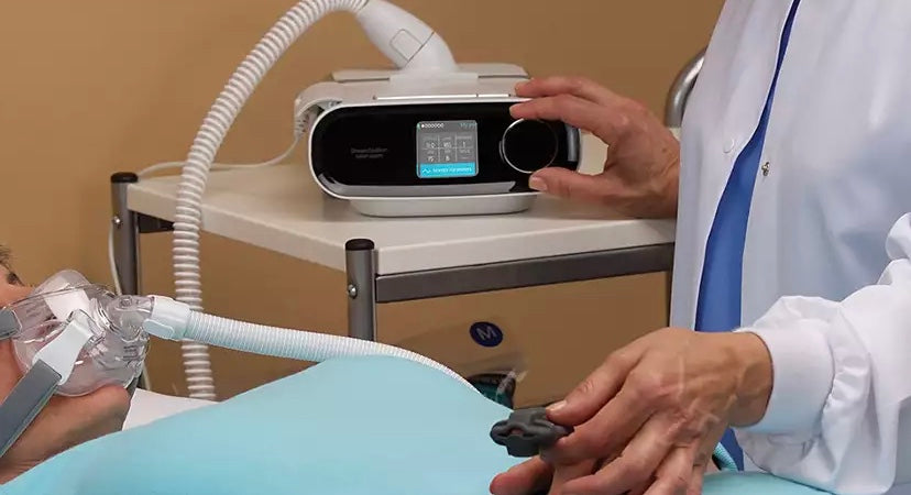 Philips DreamStation BiPAP AVAPS 30 sleep therapy device being adjusted by a healthcare professional