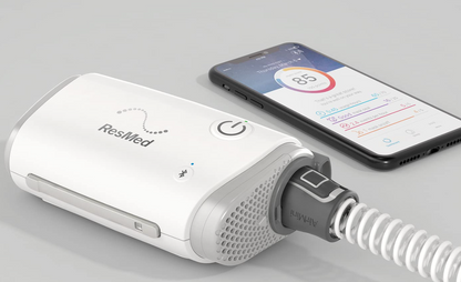 ResMed AirMini Portable Autoset compact CPAP device next to smartphone displaying sleep data