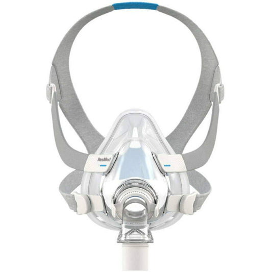 Clear resmed f20 mask with gray and blue adjustable headgear shown with a white replacement cushion